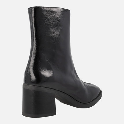 Heeled boots in black patent leather with front zipper