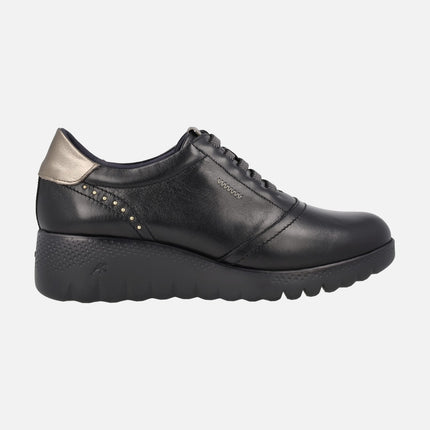 Black leather shoes with gold details and elastic laces