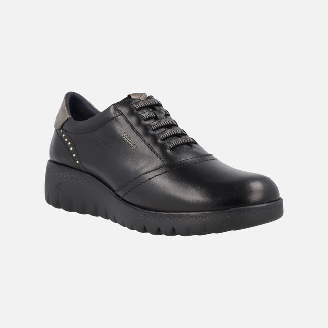 Black leather shoes with gold details and elastic laces