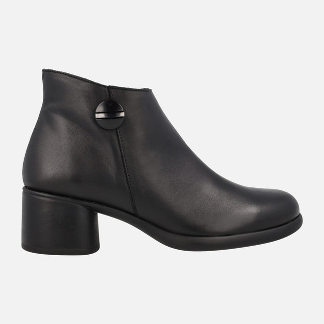 Black leather ankle boots with circular ornament and low heel