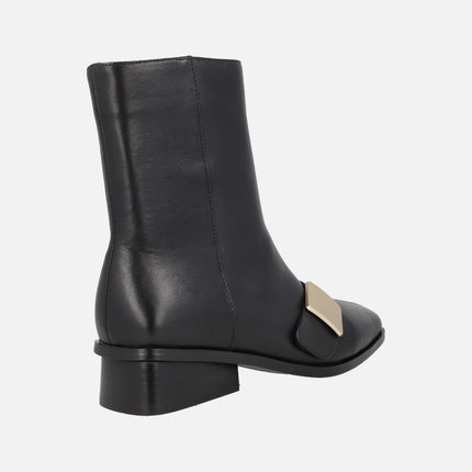 Botines en piel negra con tacón bajo y chapa dorada