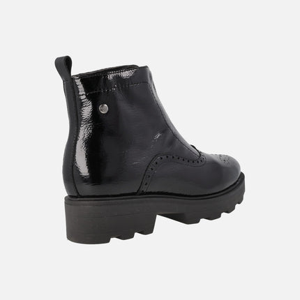 Botines con cremallera central y picados en charol negro