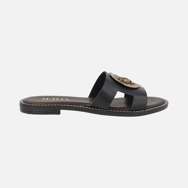 Sandalias planas de piel en color negro con adorno de sol dorado