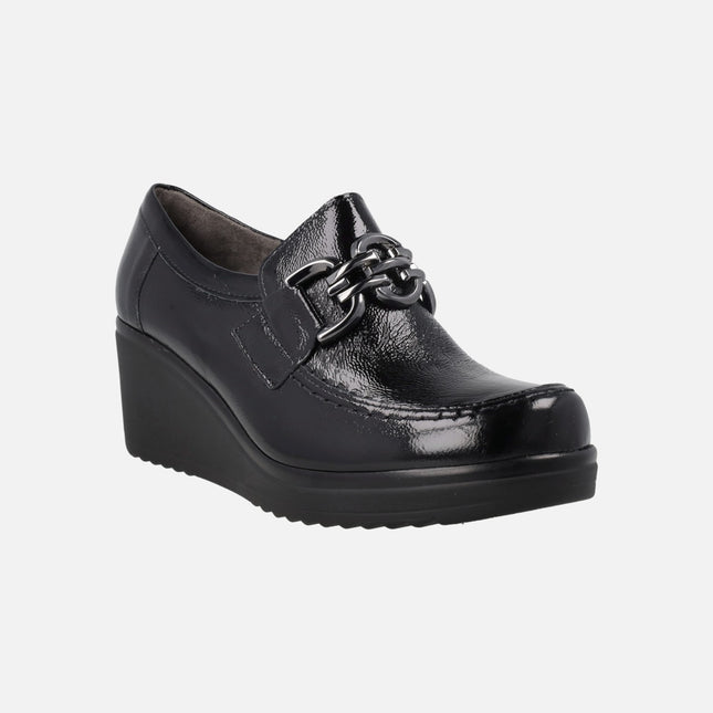 Black patent leather shoes with metallic decoration and wedge