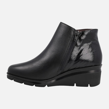 Black ankle boots in combined leather and patent leather with medium wedge